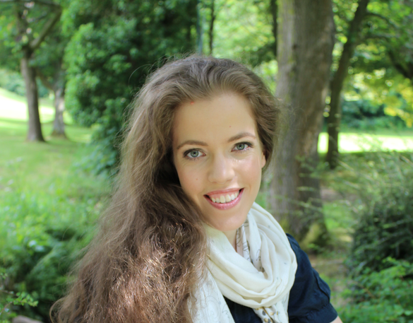 Grace Quantock wearing white scarf with a forest in the background